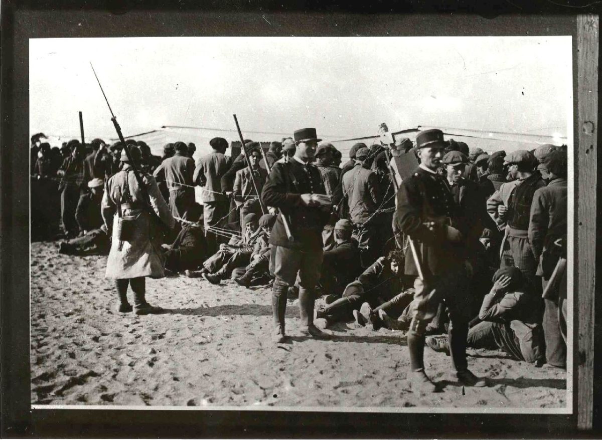 Argelès-sur-Mer, 1939 : soldats et gendarmes français surveillent les réfugiés espagnols massés derrière les barbelés, sur le sable.