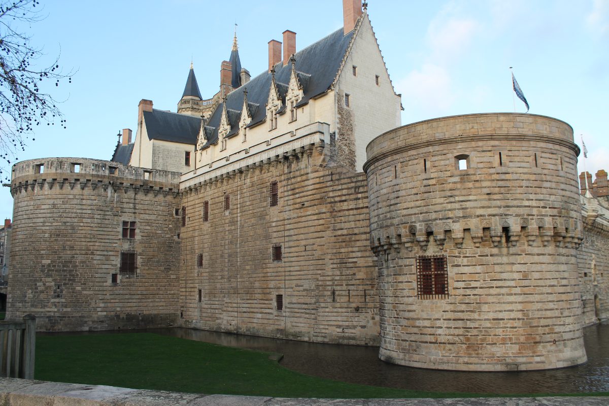 Les tours et la courtine du château de Nantes au-dessus des douves, avec le Grand Logis ducal en arrière-plan.