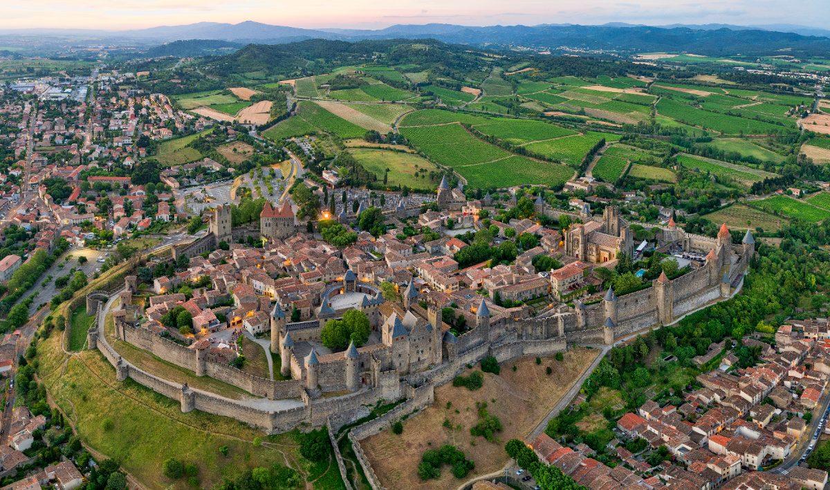 La cité de Carcassonne vue du ciel : double enceinte et tours coiffées des toits coniques en ardoise ajoutés par Viollet-le-Duc.