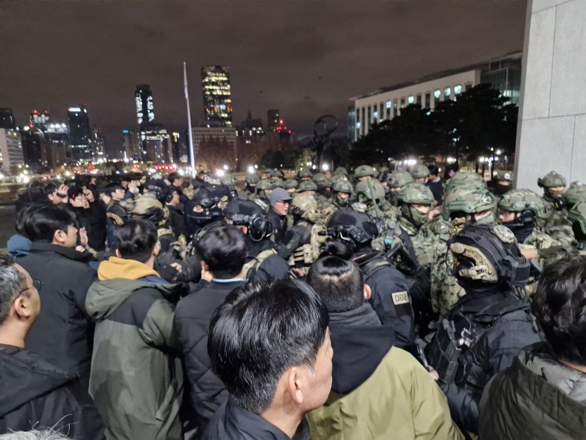 Soldats des forces spéciales face aux civils devant l'Assemblée nationale à Séoul, nuit du 3 au 4 décembre 2024.