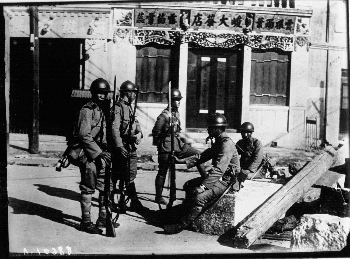 Soldats japonais en position devant une boutique chinoise aux environs de Moukden, en octobre 1931.