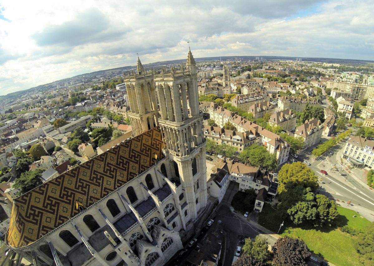 Vue aérienne de la collégiale Notre-Dame de Mantes-la-Jolie, au toit de tuiles vernissées, dominant la ville.