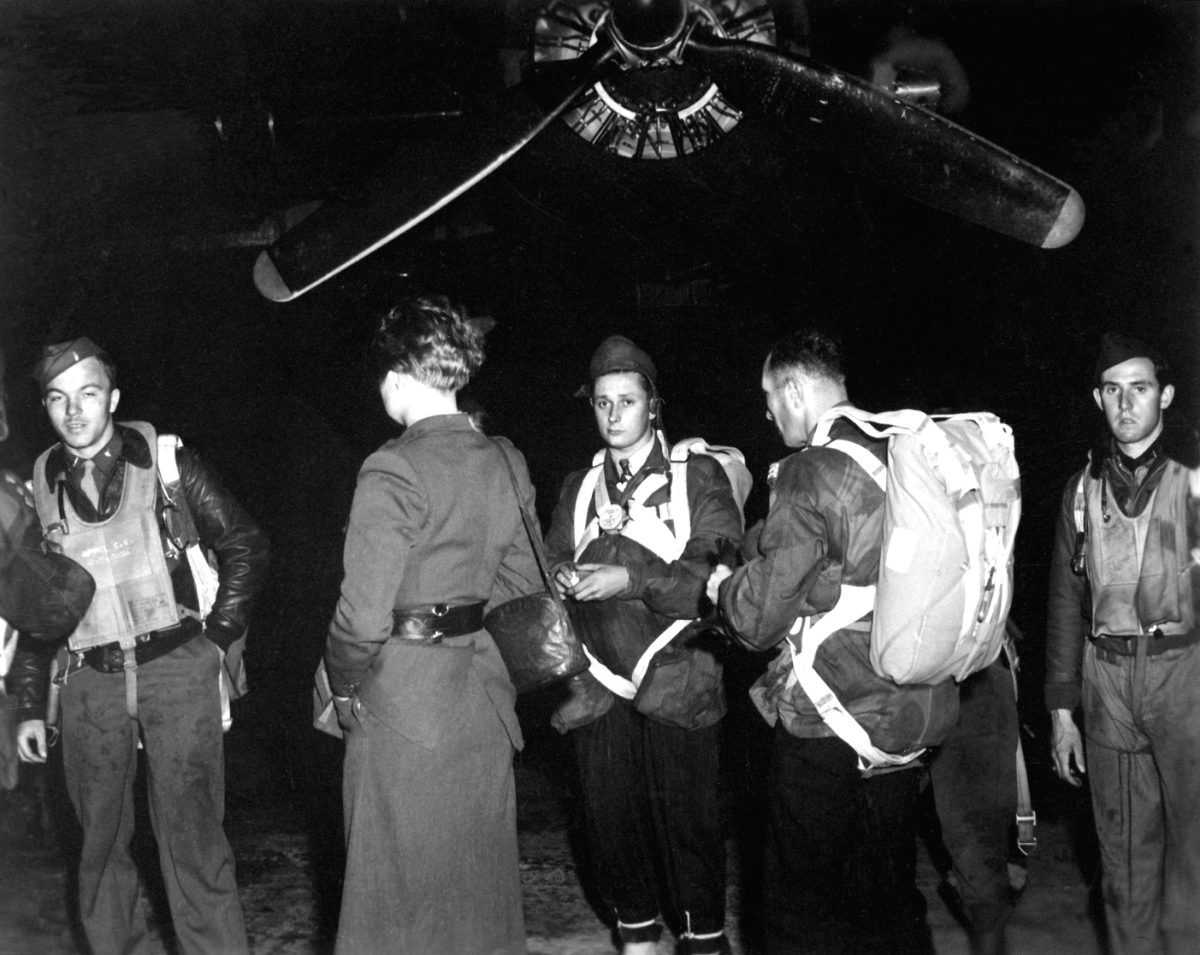 Des membres d'une équipe Jedburgh sanglent leurs parachutes devant un B-24, avant un largage nocturne en France, 1944.