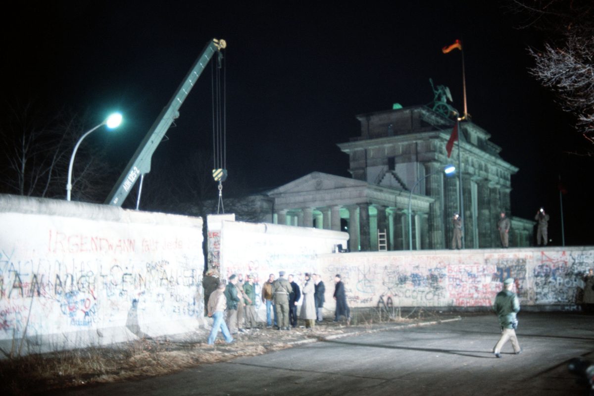 Une grue retire un pan du mur de Berlin devant la porte de Brandebourg, décembre 1989.