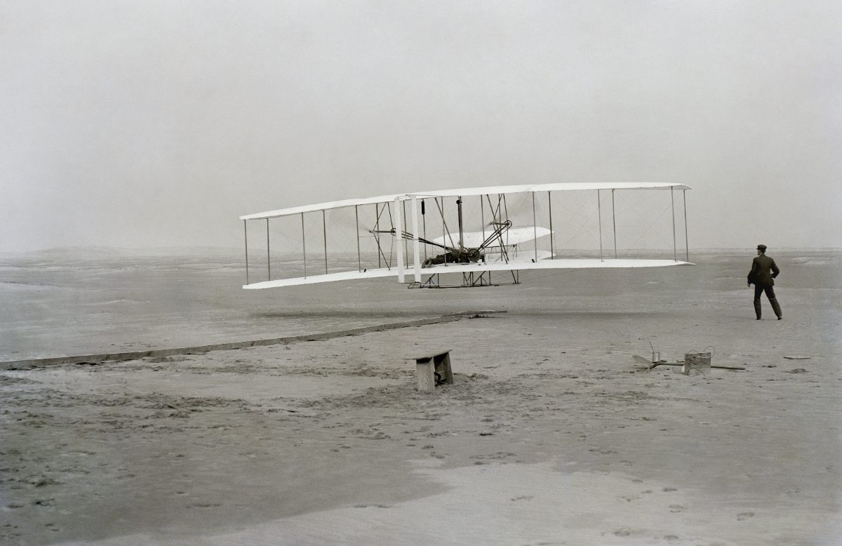 Kill Devil Hills, 17 décembre 1903 : le Flyer décolle, Orville aux commandes, Wilbur courant à l'aile.